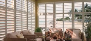 Open window shutters with the sun streaming into a room.